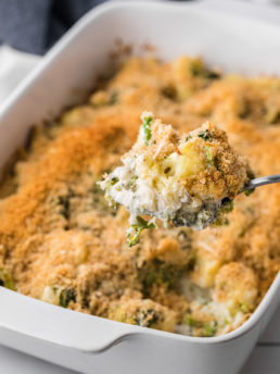 Serving spoon with Cheesy Broccoli Cauliflower Casserole