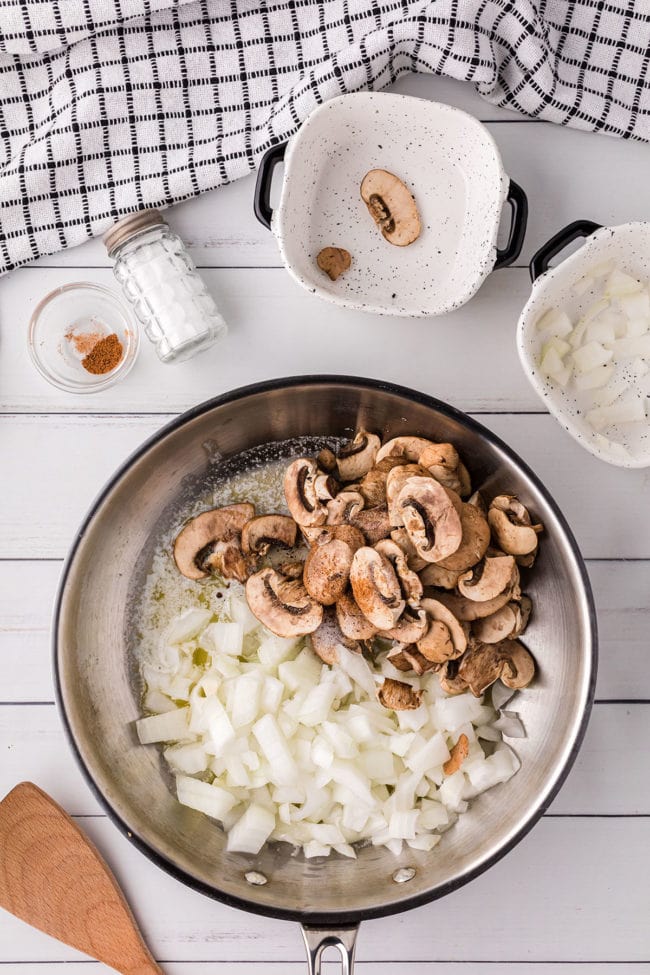 sautéing mushrooms and onions in a skillet