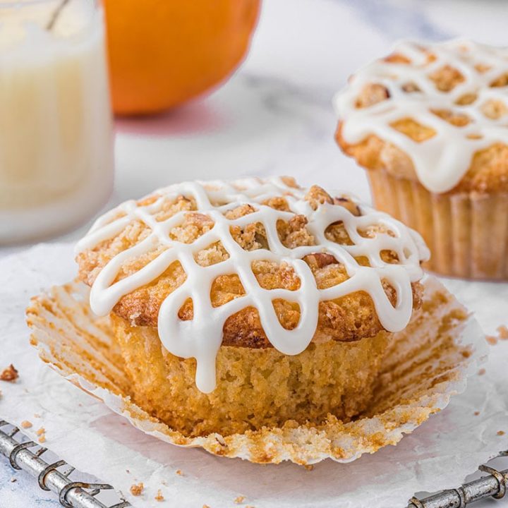 Orange Streusel Muffins on a cooling rack with parchment paper and a bottle of milk in the background