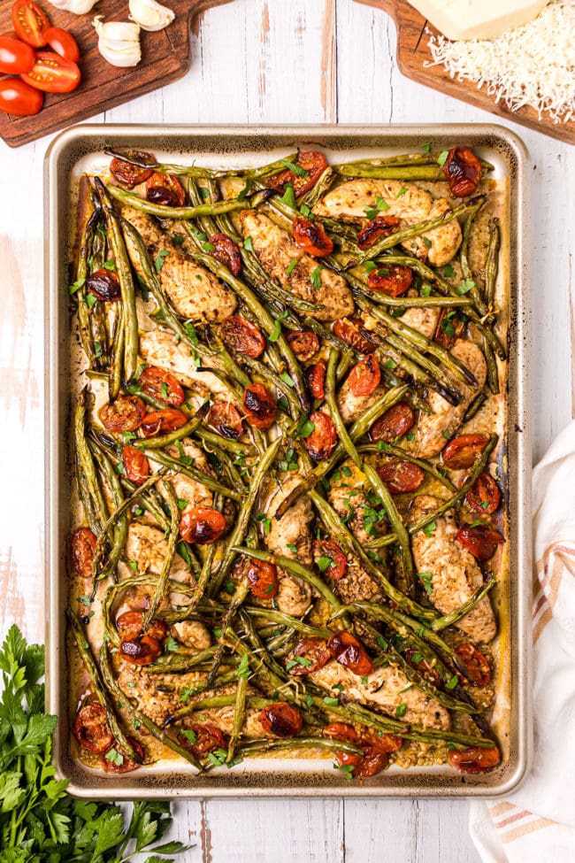 baking sheet with tuscan chicken and fresh green beans and tomatoes