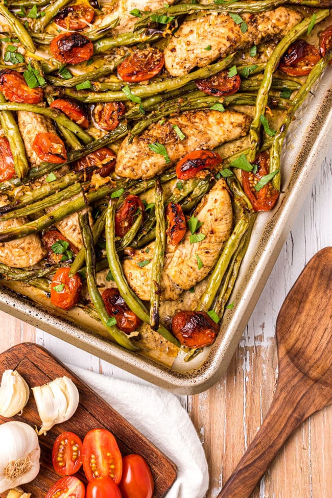 roasted chicken dinner with fresh veggies on a baking sheet