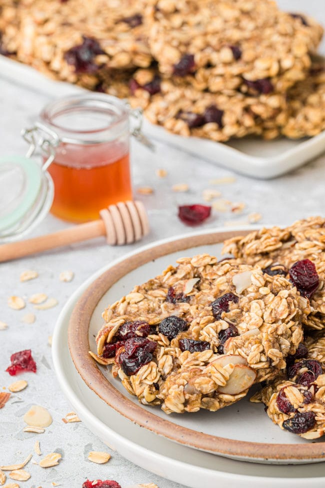 cookies on a plate and a tray along side a jar of honey