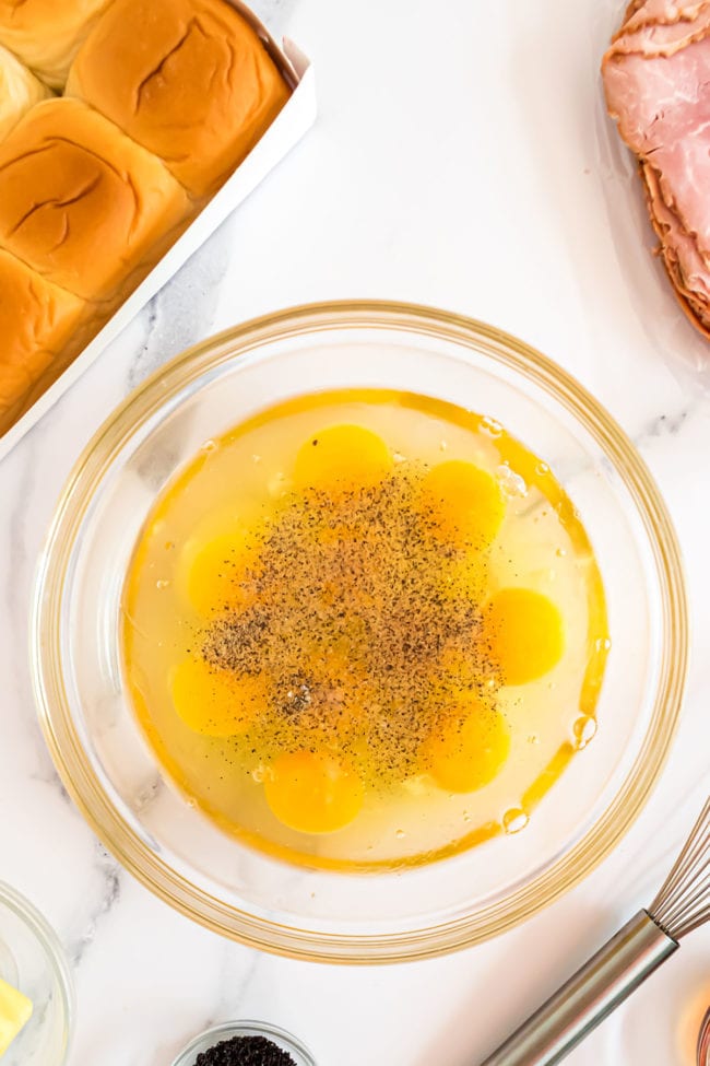 ingredients for scrambled eggs in a glass mixing bowl