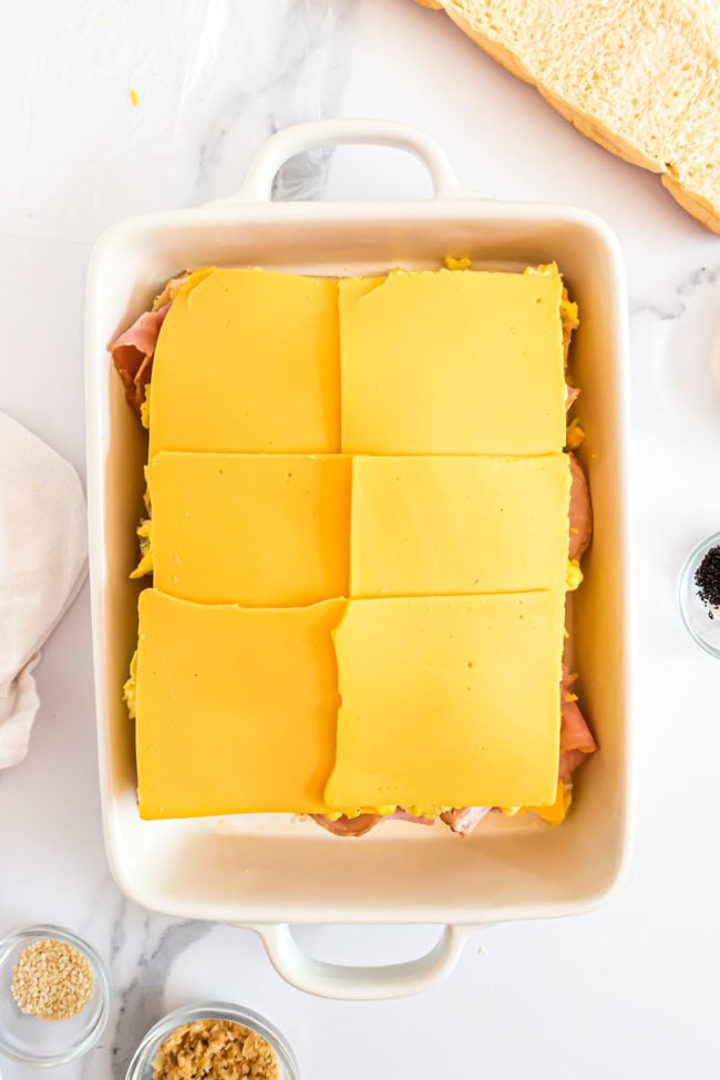 cheese layer of breakfast sandwiches in a white casserole dish