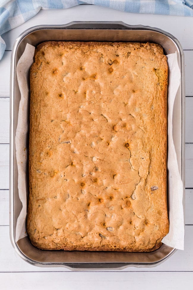 a pan of baked blonde brownies with parchment paper