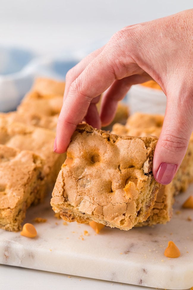 woman's hand holding a butterscotch brownie