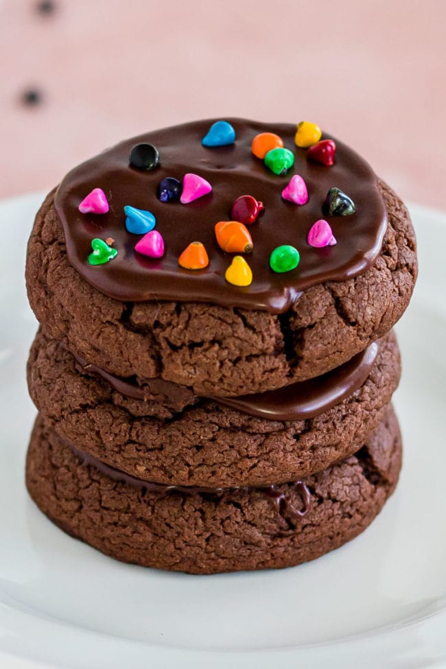 a stack of three cosmic brownie cookies with rainbow chips