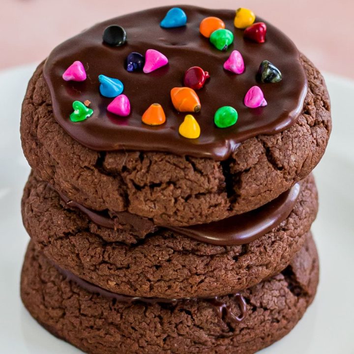 a stack of three cosmic brownie cookies with rainbow chips