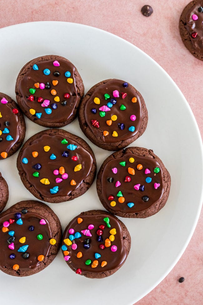 cosmic brownie cookies on a white plate with a pink background