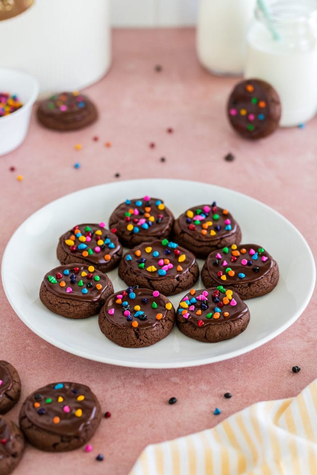 a plate of chocolate cookies with rainbow sprinkles