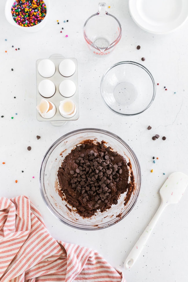 brownie cookie batter in glass mixing bowl with chocolate chips