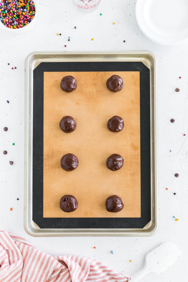 brownie cookie batter rolled into balls and placed on a baking sheet