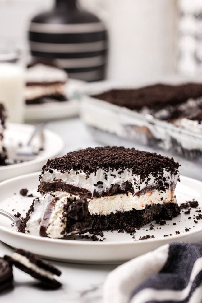 Layered chocolate lush dessert on a plate with a bite on a fork