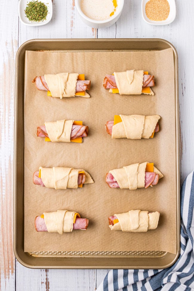 place crescent roll sandwiches on a baking sheet lined with parchment