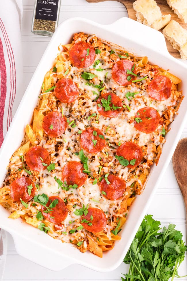 baked pizza pasta casserole with pepperoni in a white baking dish