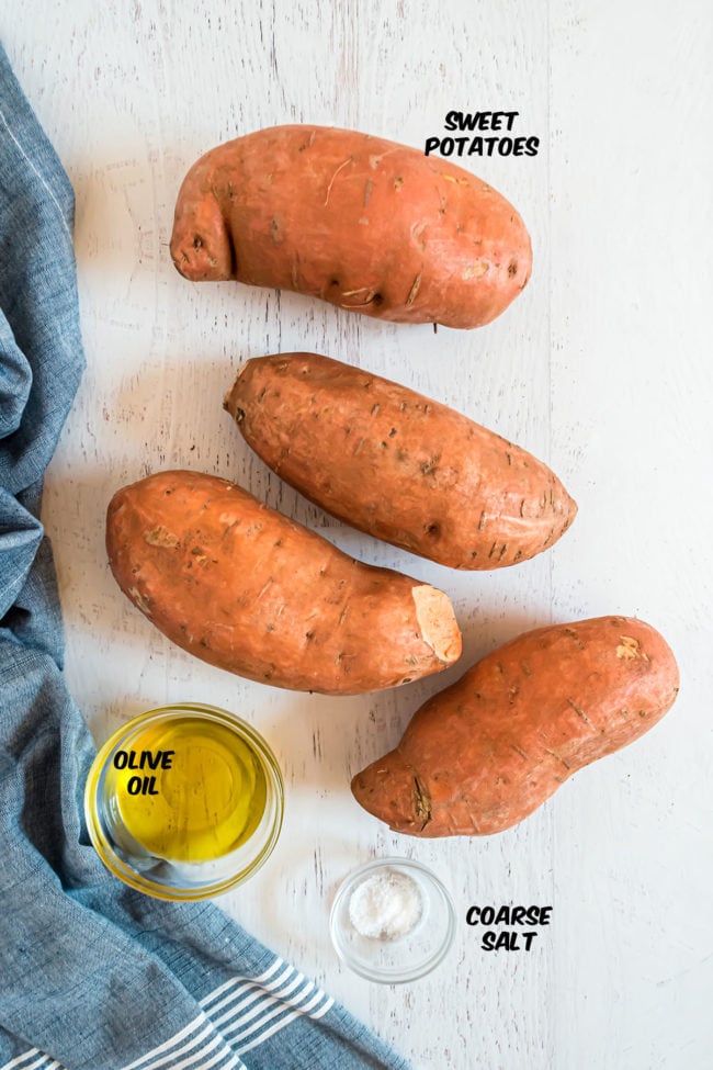 sweet potatoes with a bowl of oil and bowl of salt on a counter with a blue towel