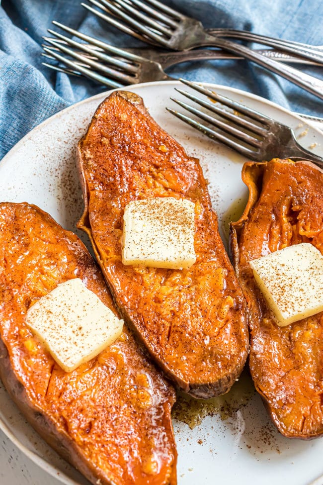 three quick baked sweet potatoes with a pat of butter and sprinkle of cinnamon