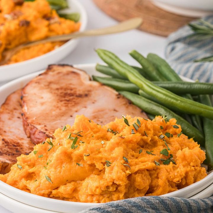 plated mashed sweet potatoes with green beans and ham