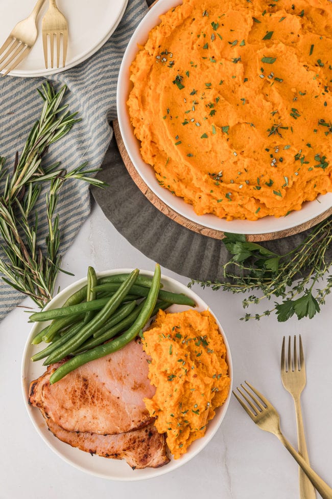 overhead shot of mashed sweet potatoes with green beans and ham