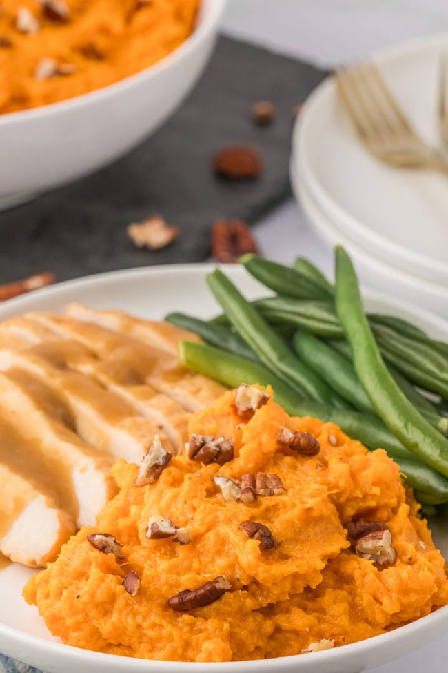 plated mashed sweet potatoes with green beans and turkey and gravy