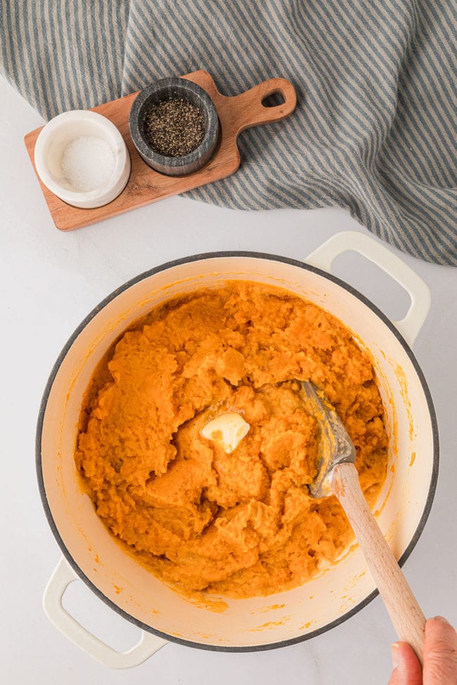 stirring mashed sweet potatoes in a warm pot