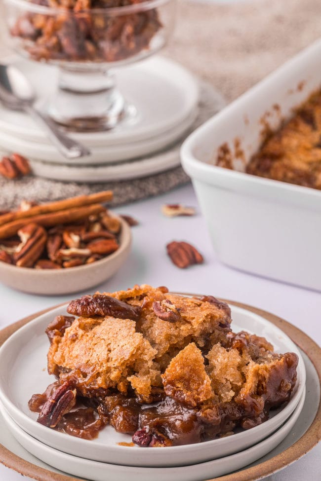 cobbler on a stack of 2 plates with the baking dish in the background