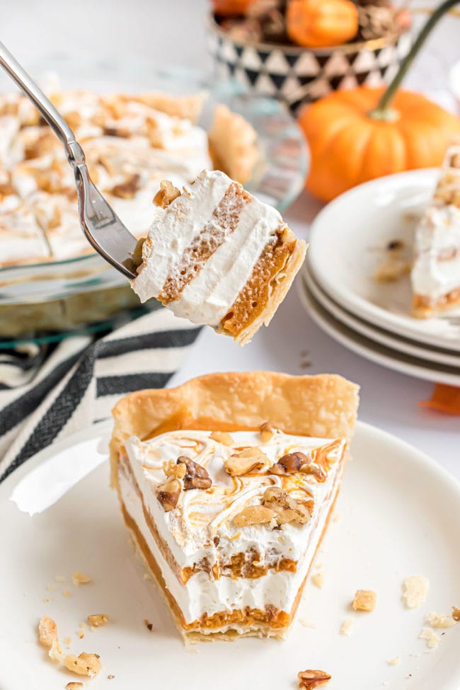 a bite of Pumpkin Chiffon Pie on a fork over a plated serving of layered pumpkin pie