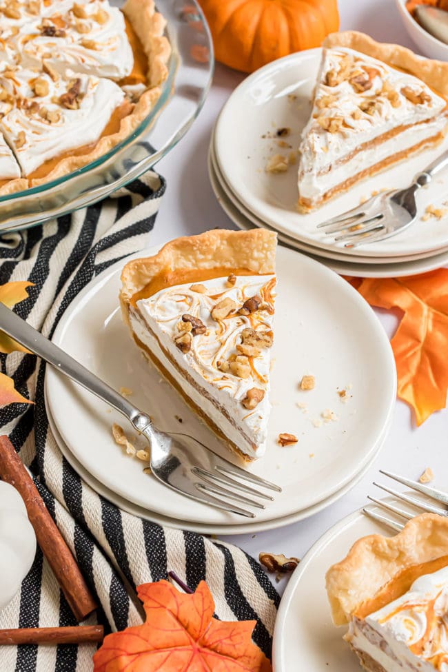 2 plated servings of pumpkin layered pie on a table next to the glass pie dish