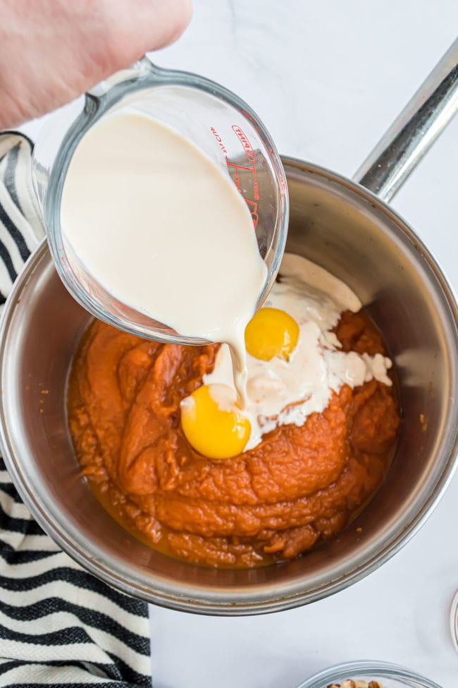 pumpkin pie filling, eggs and milk in a sauce pan