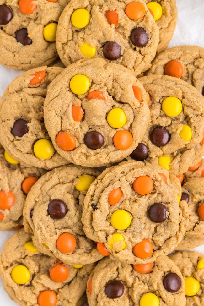a pile of peanut butter cookies with Reese's Pieces candies