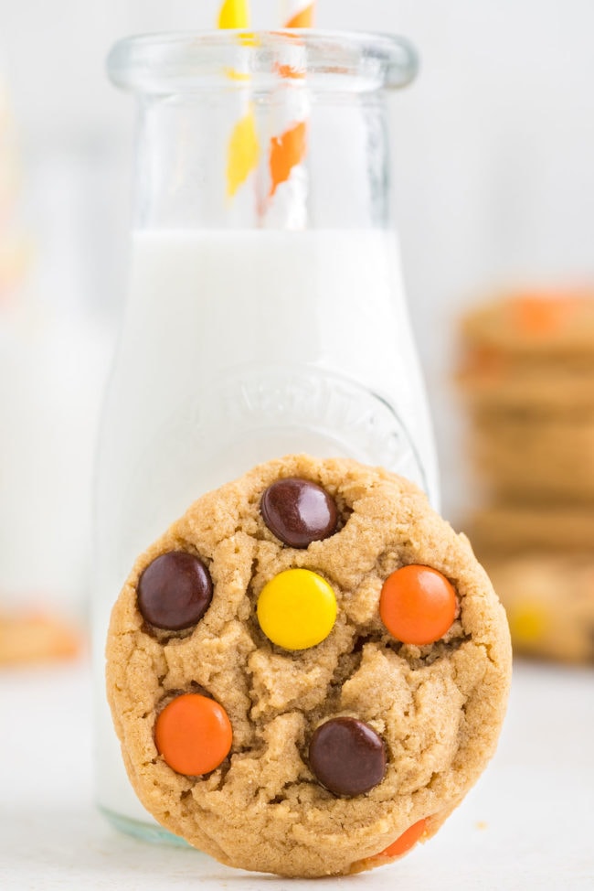 a bottle of milk with a Reese's Pieces peanut butter cookie