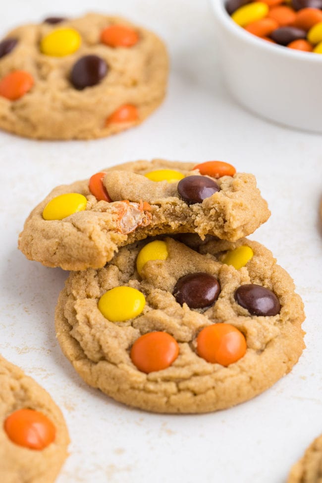 Two Reese's Pieces peanut butter cookies with a bite taken out of one