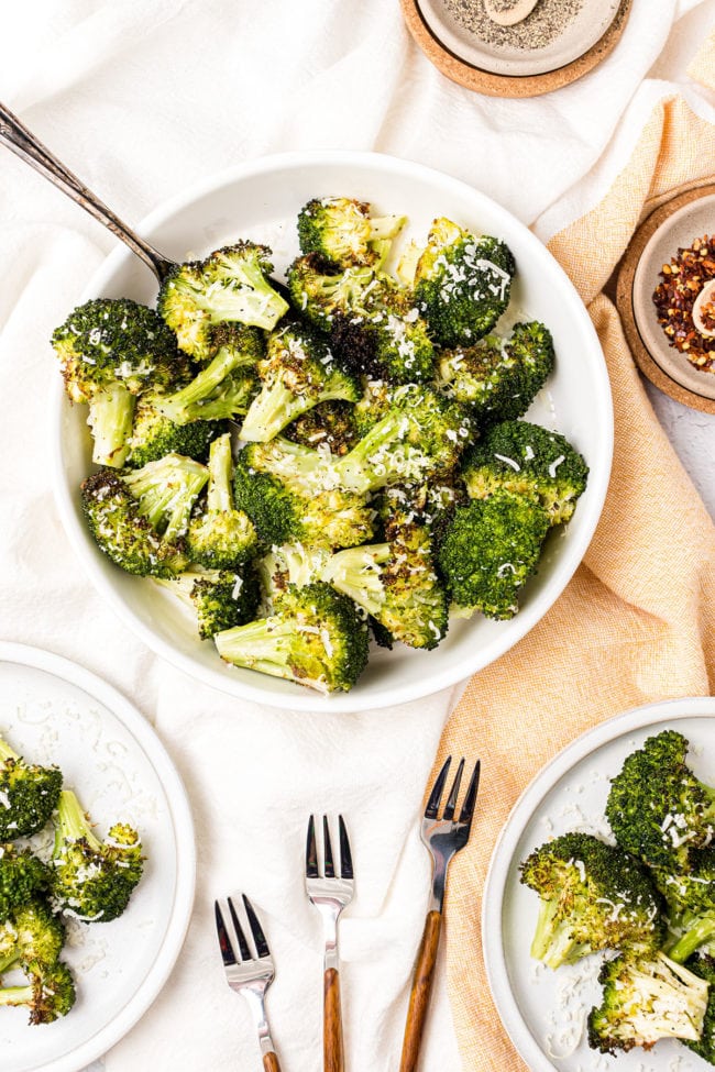a bowl of oven roasted broccoli with a serving spoon