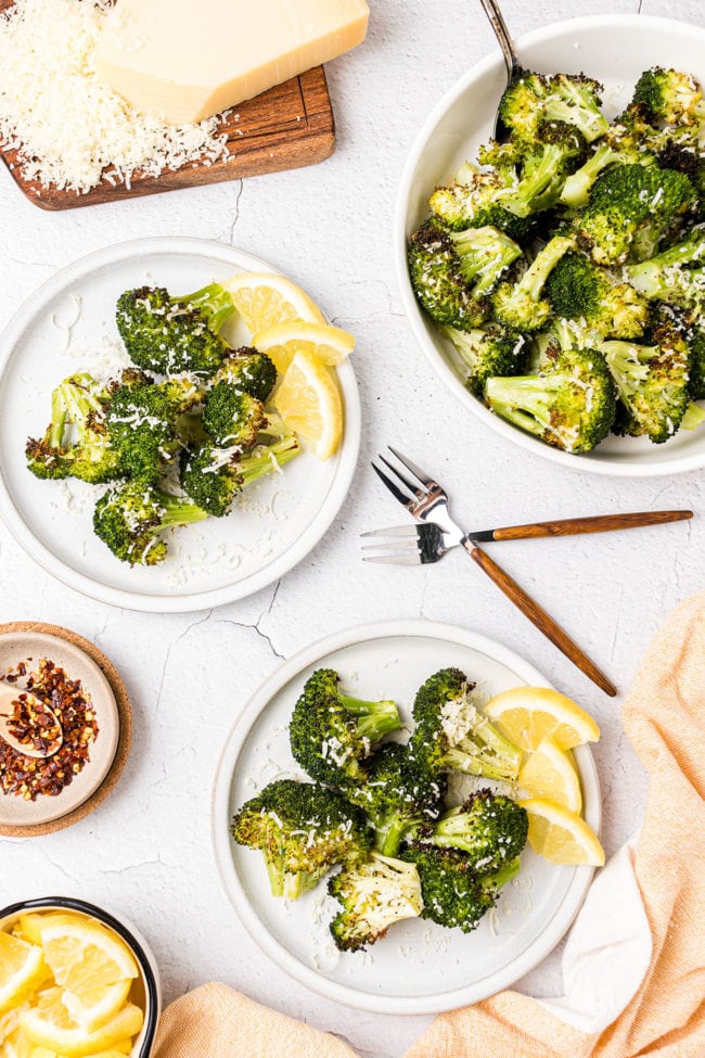 oven roasted broccoli on plates and a bowl