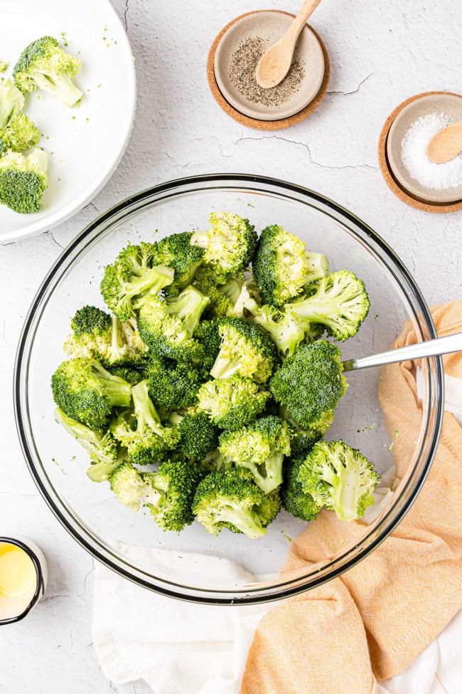 uncooked broccoli and seasonings in a glass bowl