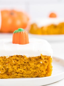 fall cake with a candy pumpkin on a white plate