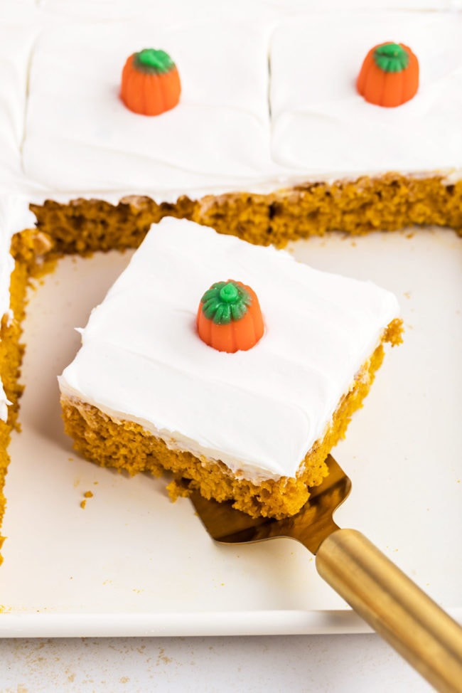 cut serving of pumpkin cake with a pumpkin candy on a cake server