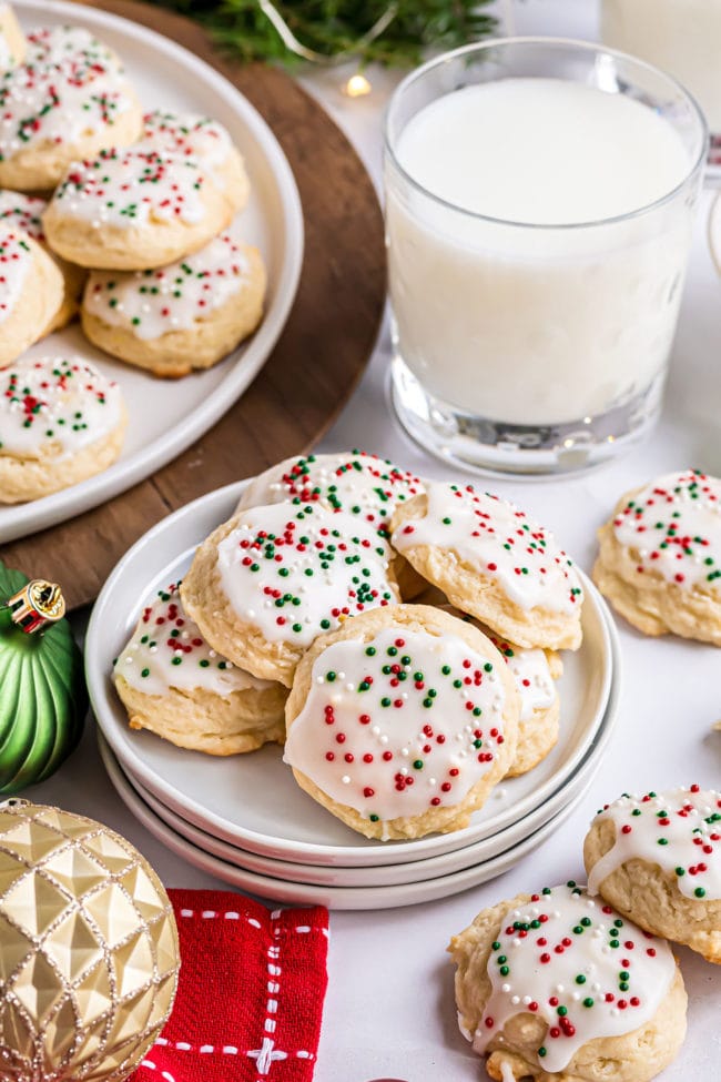 Christmas ricotta cookies on a stack of plate with a glass of milk