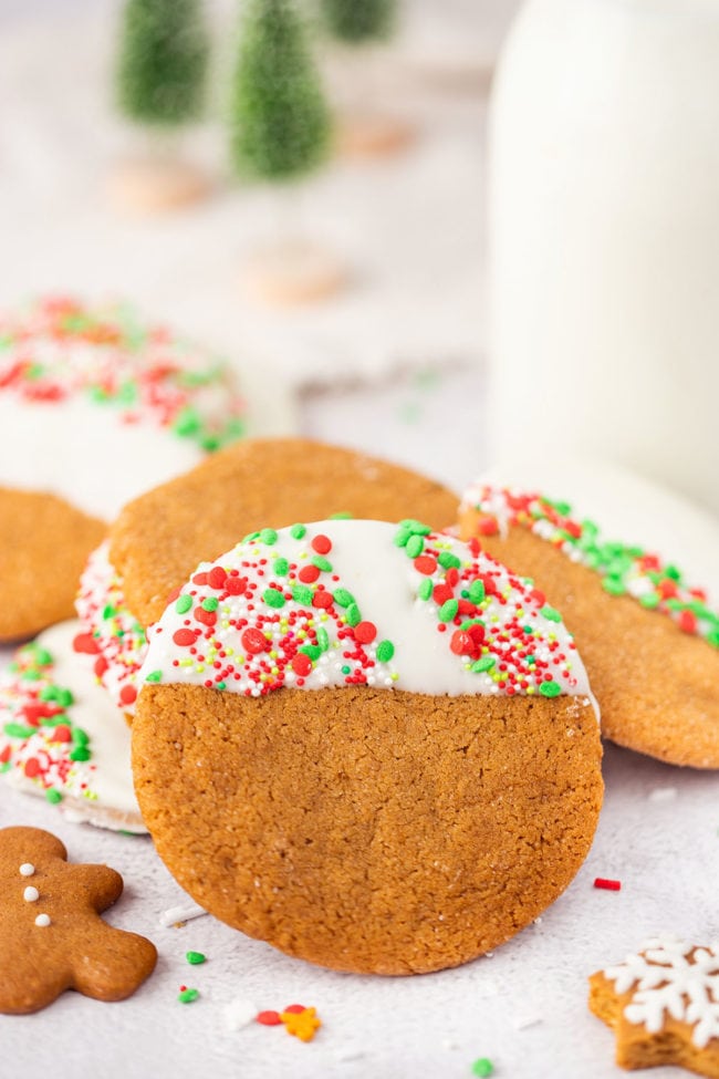stack of white chocolate dipped ginger cookies with Christmas sprinkles