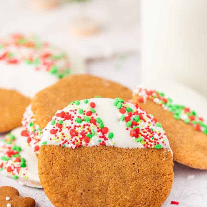 stack of white chocolate dipped ginger cookies with Christmas sprinkles