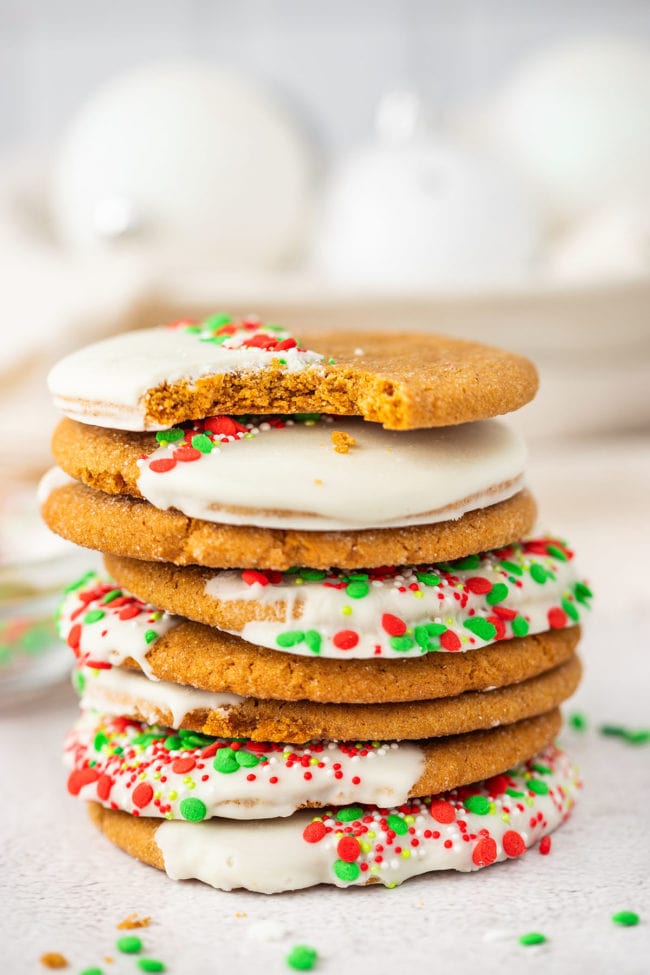 stack of ginger cookies, one with a bite missing.
