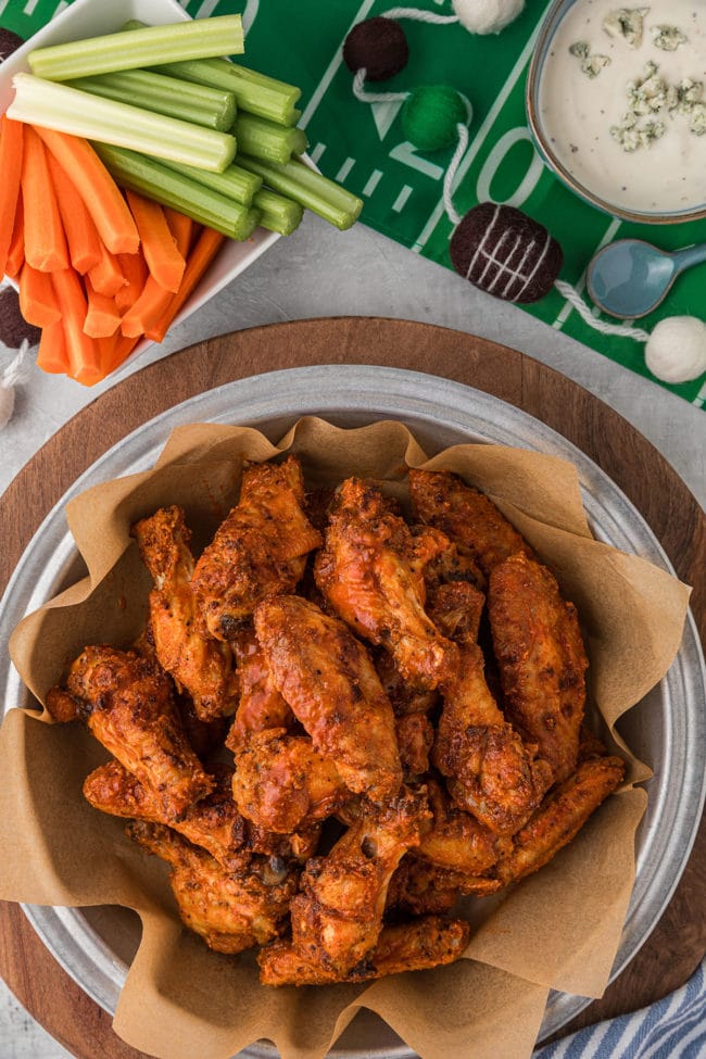 crispy oven baked wings in a bowl with carrots and celery