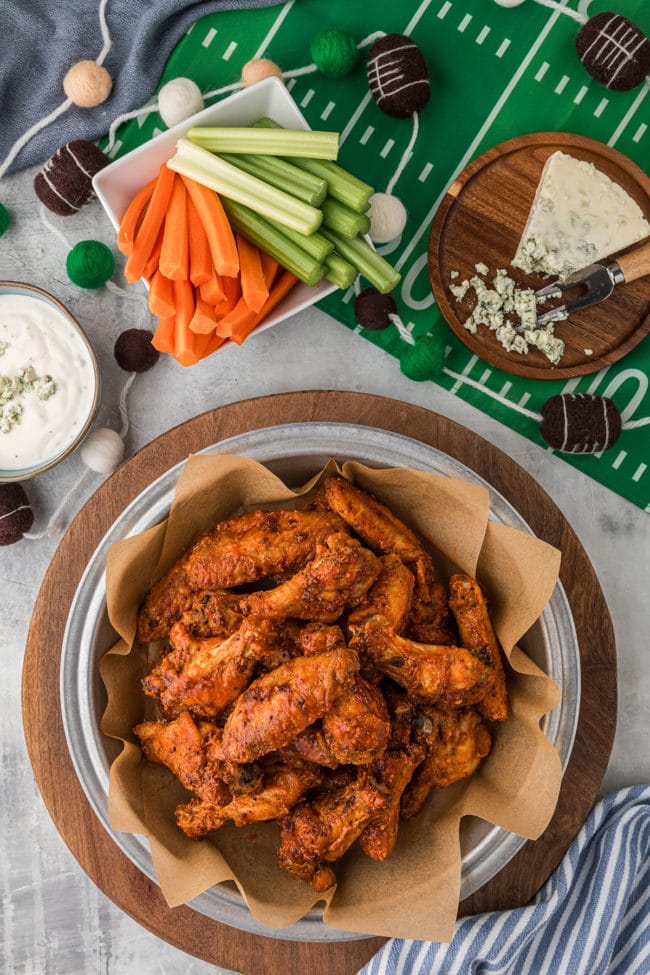 game ready crispy baked chicken wings in a bowl with football party decor