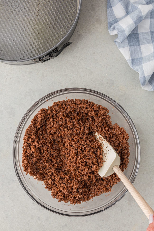 making a chocolate cookie crust in a glass mixing bowl