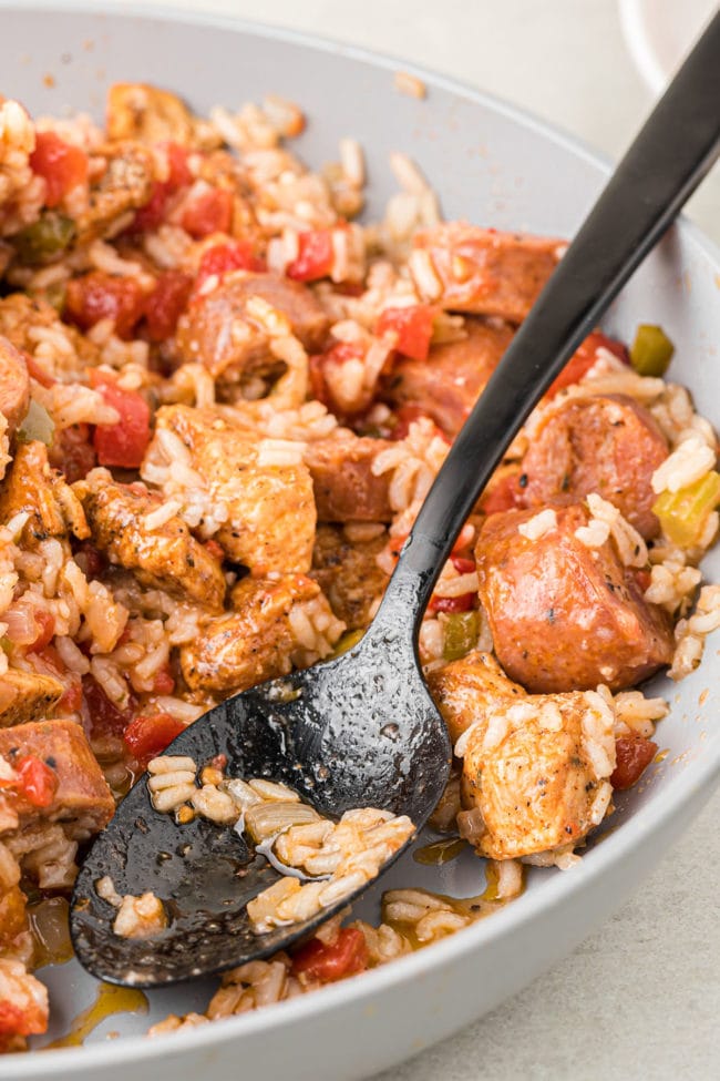 Sausage Chicken Jambalaya in a bowl with a black serving spoon