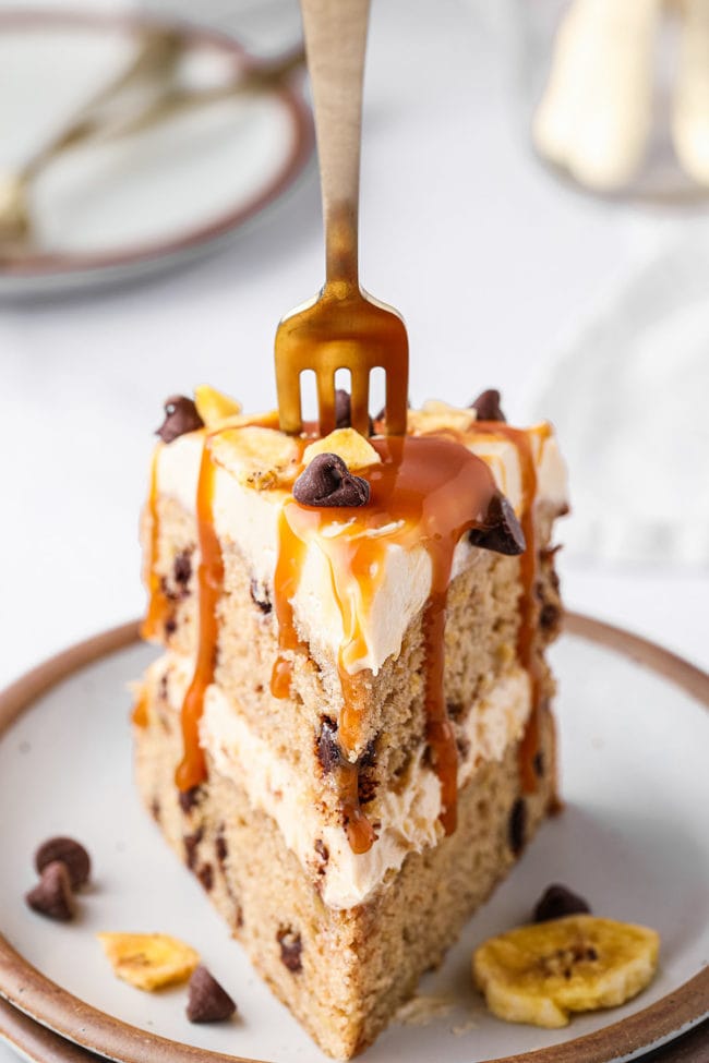 slice of banana layer cake with a gold fork