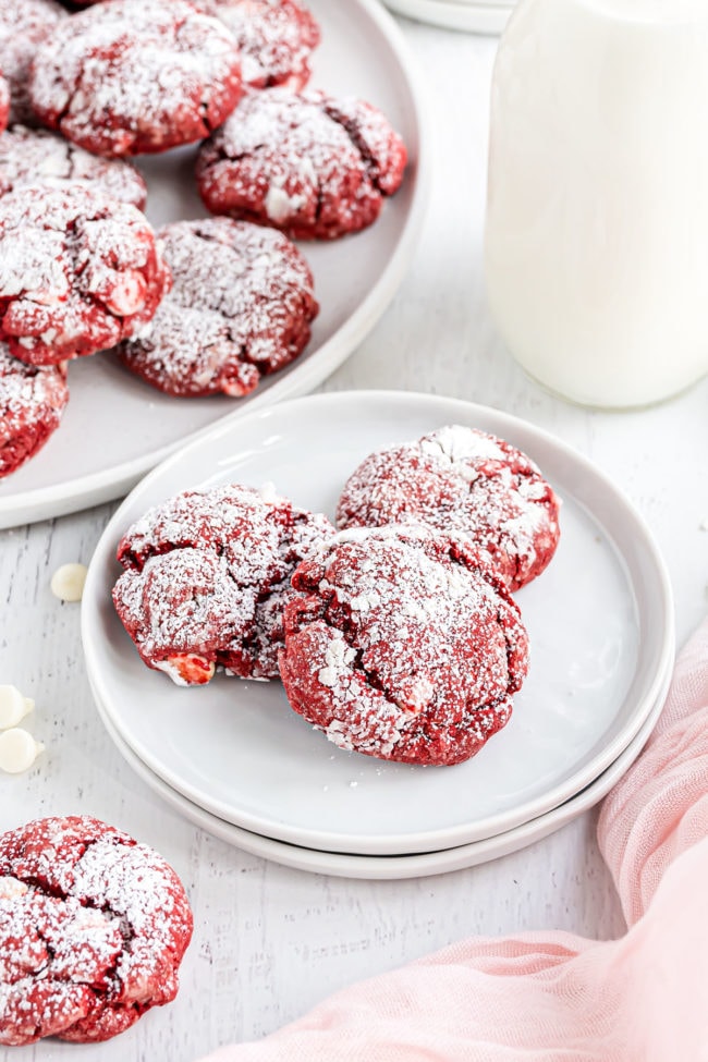 red velvet cookies with a bottle of milk and pink towel on a counter