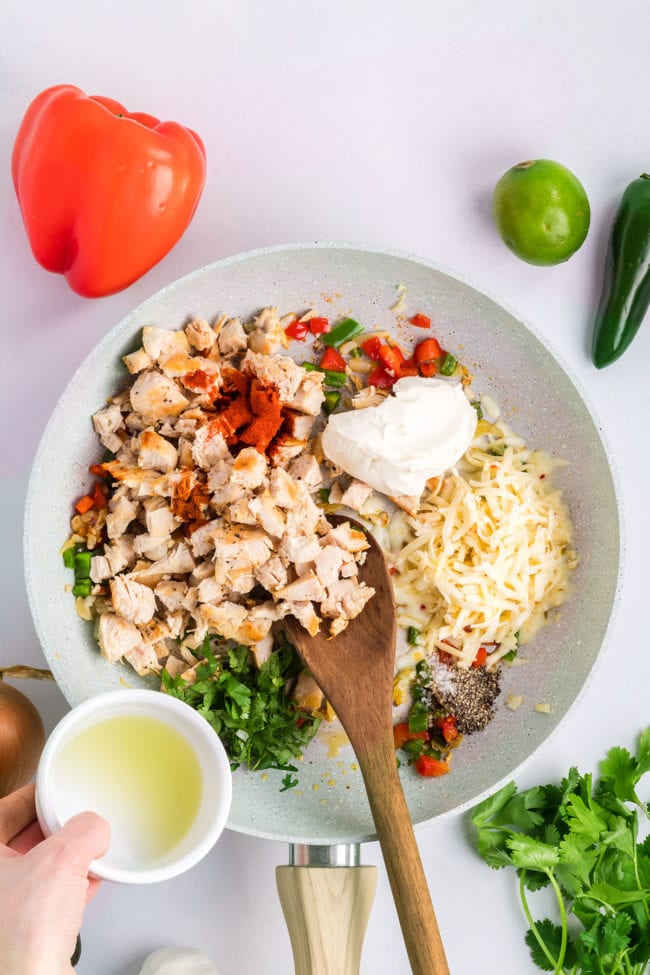 mixing firecracker chicken wrap filling in a skillet