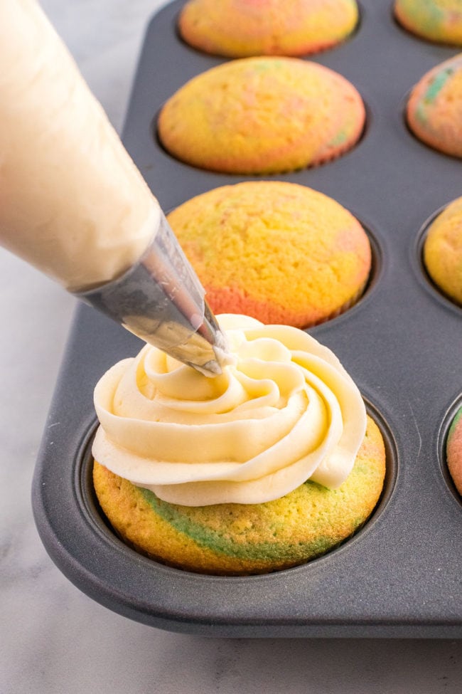 piping frosting on a Spring cupcake