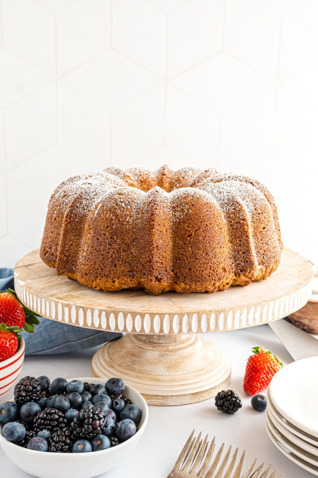 pound cake that was baked in a fluted tube pan with fresh fruit and plates about it